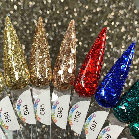 The "Holiday Sparkle" Acrylic Powder Collection by Dynamic Nail Supply showcases a range of pointed false nails with a dazzling gradient of glittery colors such as gold, champagne, red, blue, and teal. These numbered nails offer long-lasting wear and are set against a sparkling silver backdrop to amplify the festive and glamorous spirit for the upcoming Christmas 2024 season.