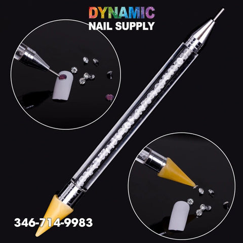 The Dual-ended Nail Art Wax Dotting Pen Picking Up Rhinestone by Dynamic Nail Supply showcases a metal tip on one end and a yellow silicone tip on the opposite side. Against a black background, two images display how the pen adeptly applies rhinestones to a nail. "DYNAMIC NAIL SUPPLY" is prominently featured at the top, with "346-714-9983" noted at the bottom.